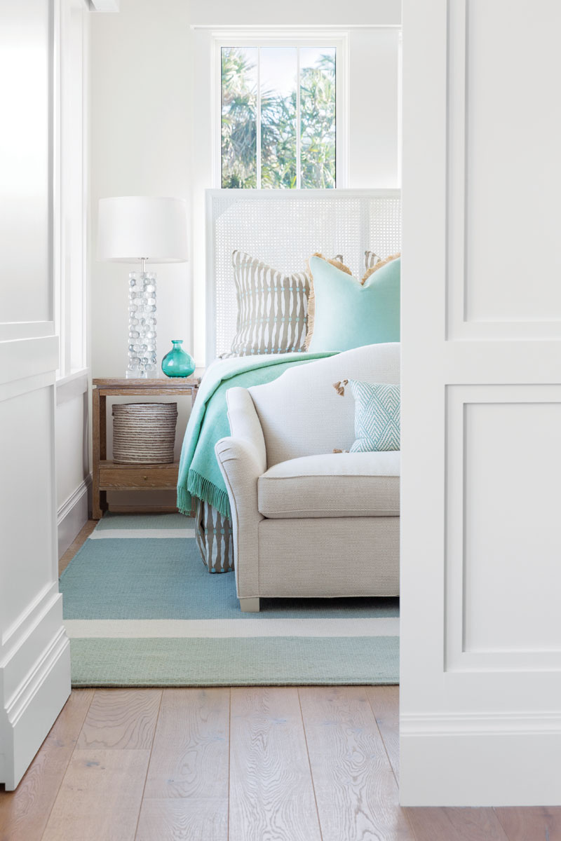 With windows everywhere, arranging the furniture in the bedrooms was a challenge. Thompson designed the headboards so they don&rsquo;t block light. When the guest bedroom doors are closed, they seamlessly blend into the paneling in the hallway.