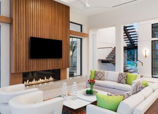 Walnut accents in the great room echo the exterior design and warm up the all-white walls and furnishings. Pops of bright colors were strategically designed to be removed if the new owner didn’t like them. “People are sometimes afraid of color and it would be difficult if I put in a red sofa, so I kept it to small accessories,” says McDaniel.