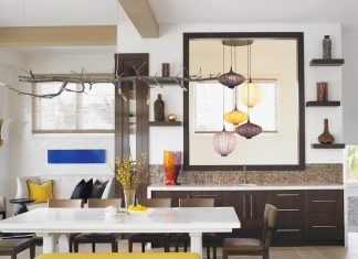 In the dining room, a lacquered white table is surrounded by chairs and a bright yellow bench, anchoring the room with eclectic charm. A branch lighting fixture custom designed by Liegeois and pendant lights that mimic paper lanterns add color and personality to the space. “The lanterns are so unique, they bring a smile to my heart every time they’re on,” says homeowner Susan Baierl. “The neighbors appreciate them at night as well, telling us how beautiful they look from the windows.”