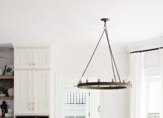 Mediterranean-Inspired Splendor in Tampa Home Black Windsor-style chairs lend a striking visual contrast to the natural wood grain of the kitchen table. A black Arteriors chandelier brings the perfect complement to this cozy space. Awash in natural light, the area is a favorite spot for breakfast and casual family meals.