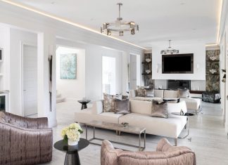 Multiple seating areas in the grand salon make it a perfect place for entertaining guests. With pearlescent accents on the chairs and pillows, stylized marine art, and stark-white coral pieces on display, the room is coastal chic without the clichés the style can imply.