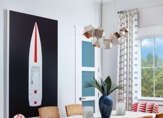 A dynamic artwork by Mat Sanders, Speed Boat 2, sourced from the Wendover Art Group, anchors the dining room. The dining table is made of mahogany finished in a warm neutral topped with a glaze. A dynamic red-and-white Pollock fabric on the host and hostess chairs creates a bright, resonant element in the space.