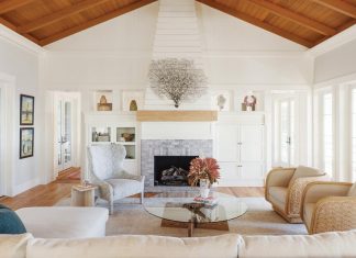 Gulfside Serenity in Gasparilla Island Beach House A whitewashed brick gas fireplace topped by a large sea fan is the focal point of the living room. Local objects nestle in the built-ins while a linen sofa and rope-adorned swivel chairs provide flexible seating. The transparency of the coffee table helps keep the room feeling light.