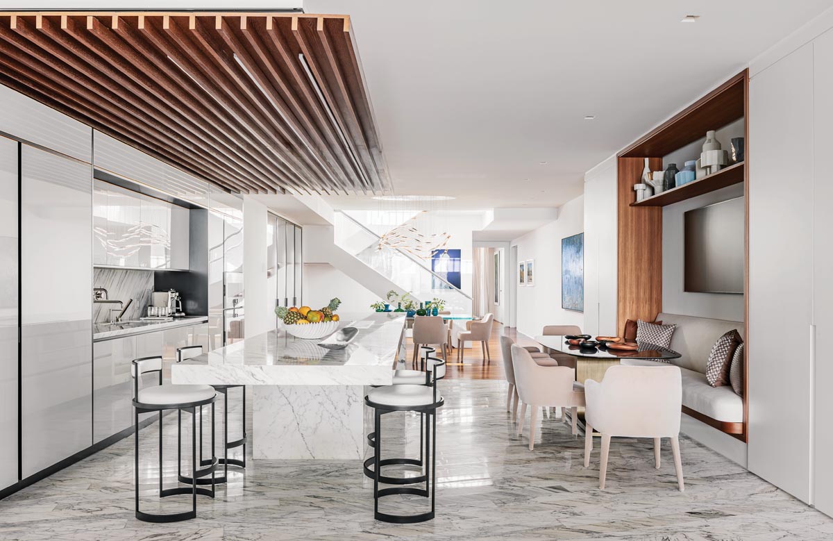 The kitchen&rsquo;s sleek linear design includes a custom banquette by Wecselman Design that integrates a casual dining space for the family. Powell & Bonnell Nobi swivel stools outfit the island and mesh seamlessly with modern Febo dining chairs from B&B Italia and a Sovet Italia breakfast table from Arravanti.