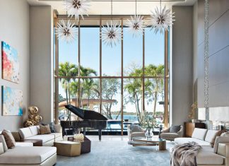 Over the Top Luxury in Orlando Home Floor-to-ceiling windows frame the great room’s pool deck and lakefront views. John- Richard’s starburst pendants hover over a glossy grand piano and custom artwork by Liv Dockerty. Contemporary seating arrangements suitable for large gatherings or intimate conversations include Wise Living sectionals, Baker lounge chairs, and Mark Jupiter cocktail tables.