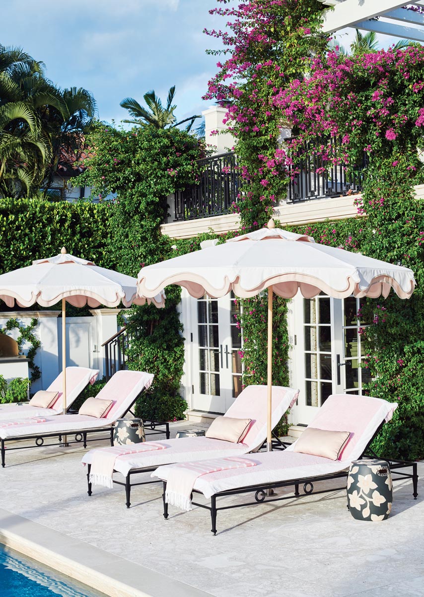 Poolside furnishings feature a retro black-and-pink color scheme. The scalloped trim on the parasols echoes the cornice trim on the loggia.