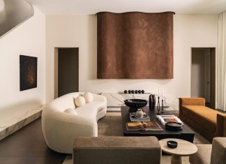 Modern Fort Lauderdale Home is Neutral Territory In a completely renovated and expanded Fort Lauderdale home, the focal point of the modern living room is a fireplace that combines a linear marble base with an asymmetrical decorative sculpture finished in a leather-like Roman clay by Portola Paint. The rich, yet neutral color palette continues in the furnishings with a custom-designed, curvy bouclé sofa offsetting the more linear RH bench and Maiden Home chairs.