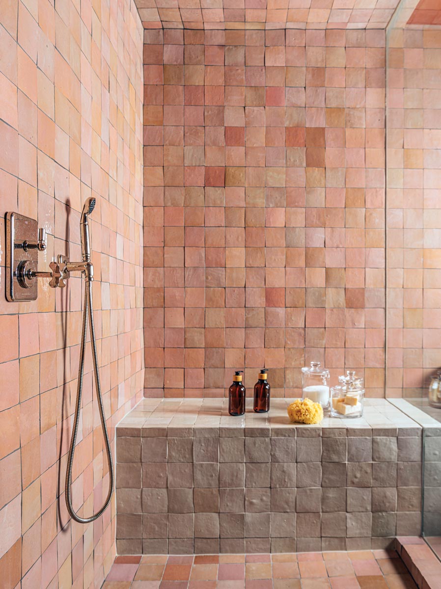 The lower level of the residence houses a home gym with a stylish spa bathroom and a steam room outfitted with rose-colored Moroccan tiles from Cl&eacute;.