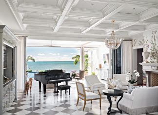 Key Largo Home is a Refined Seaside Dream Intricately coffered ceilings and black and white floors from Devon Tile & Design Studio clad the living room in quiet grandeur, artfully framing the seascape. A high-lacquered, custom Chippendale-style bar with mirrored panels subtly reflects the sea and sky, and the ocean-facing grand piano embodies the sheer splendor of the space.