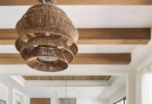 Inside a Collected and Curated Family Home on the Manatee River The living room’s soaring height demanded an overscale light fixture with a woven finish that adds to the resort-like ambience. Immediately noticeable are the white oak beams on the ceiling, which bring a sense of warmth to the room. Neutral furnishings below keep the room’s textures balanced.