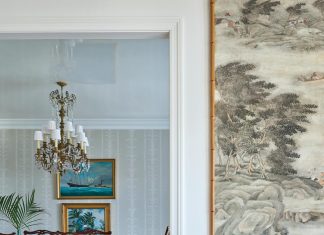 A well-balanced mélange of old and new continues in the dining room, refreshed with a Waterhouse Pavilion Stripe wallcovering from John Rosselli & Associates. The room is anchored by a textural seagrass area rug from Rush House.