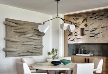 Pelican Bay Condo Radiates Elegant Warmth Art by Gwen Hardie and a Sequoia stool-pouf by Fredericia adorn the hallway that leads to the primary bedroom.