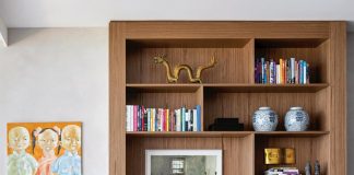 An Asian artwork in the living room nods to the time the family spent in China. A custom oak shelf holds mementos and antiques collected by the homeowners over the years. The vintage Poltrona Mole chair and ottoman by Sergio Rodrigues reveals Saliba’s penchant for Brazilian mid-century modern furniture.