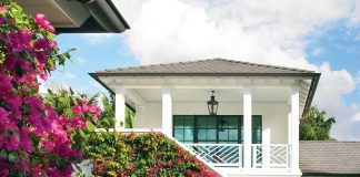 Designed by New York architect David Neff, the Bermudian-style house features an unexpected layout and U-shaped footprint, creating a surprisingly deep backyard. Draped in blossoming bougainvillea, the pool area features Neff’s clever arched built-in seating niche against geometric green tiles from Ceramic Matrix.