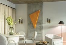 In the condo’s dining area, chairs designed by Leon Rosen for Pace Furniture in the 1970s introduce a refined sense of heritage with their arched backs and Lucite arms, which quietly echo a Roman arch motif. The orange triangular painting on the exposed concrete wall was created by designer Paul Sherrill’s business partner, José Solis Betancourt, who gifted it to him as a housewarming present. “When I saw it in his studio, I knew it was the one piece that would add an unexpected touch to the room,” says Sherrill.