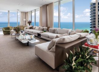 Sunny Isles Beach Residence is Serene and Sophisticated The main living room’s design is refined yet welcoming and centered around the view with a strong sense of balance and spatial organization. “Because of the room’s length, we divided it into two distinct zones: a TV/living area and a bar/lounge space for entertaining,” says designer Cristina Souza. “A custom extended sofa helps define these areas.”