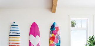 Because the main living area of the home is so large, designer Kate Abt created a couple of sitting nooks for quiet moments. On the wall, colorful surfboards by Kerri Rosenthal reveal the family’s love for the sport.