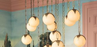 The Alesa chandelier by Corey Damen Jenkins for Eichholtz features alabaster orbs on brass strands