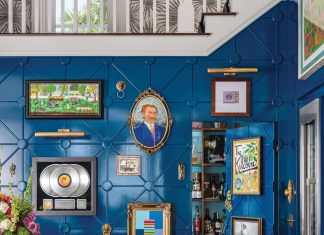 Tampa Home is a Study in Refined Eclecticism The bar is a showcase for artworks collected over the years. The mix of deep blue on the wall paneling and yellow on the stools is exemplary of the bold approach to palette exhibited throughout the residence.