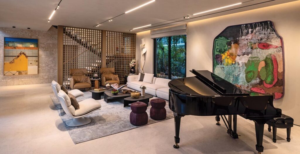 A photographic work by Brazilian artist Eduardo Rezende presides over the entry to the living room, where sculptural lounge chairs and a Supermoon sofa from Minotti combine with Poltrona Frau leather chairs and Poliform’s Koishi cocktail tables. A painting by Detroit-based artist James Benjamin Franklin occupies an esteemed position behind the grand piano.