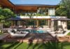 Designed around an L-shaped floor plan by architect Cesar Molina, the residence opens onto a resort-inspired outdoor environment where the pool, covered terraces, and tropical landscape form the heart of the home, blurring the boundaries between indoor and outdoor living. A Tesla Solar Roof system supports both sustainability and resilience without compromising the architecture.