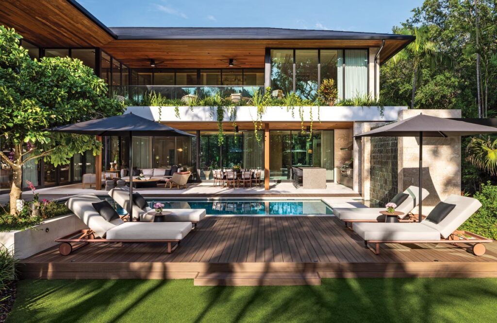 Designed around an L-shaped floor plan by architect Cesar Molina, the residence opens onto a resort-inspired outdoor environment where the pool, covered terraces, and tropical landscape form the heart of the home, blurring the boundaries between indoor and outdoor living. A Tesla Solar Roof system supports both sustainability and resilience without compromising the architecture.