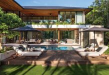 Designed around an L-shaped floor plan by architect Cesar Molina, the residence opens onto a resort-inspired outdoor environment where the pool, covered terraces, and tropical landscape form the heart of the home, blurring the boundaries between indoor and outdoor living. A Tesla Solar Roof system supports both sustainability and resilience without compromising the architecture.