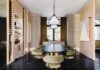 Pinecrest Family Home Balance Elegance and Comfort Nero Marquina marble flooring anchors the dining room and serves as a contrast to other textures, mainly the custom wallcovering and blond oak millwork. Nuevo Living chairs upholstered in green velvet surround a dining table by Made by Moniomi. Pendants by Gabriel Scott introduce a slight industrial vibe in the room.
