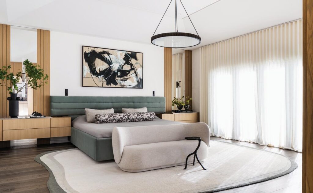The design approach in the primary bedroom centered on restraint and balance—a soft, tonal palette, layered natural materials, warm wood finishes, textured fabrics, and sculptural furnishings to create depth without relying on bold color.