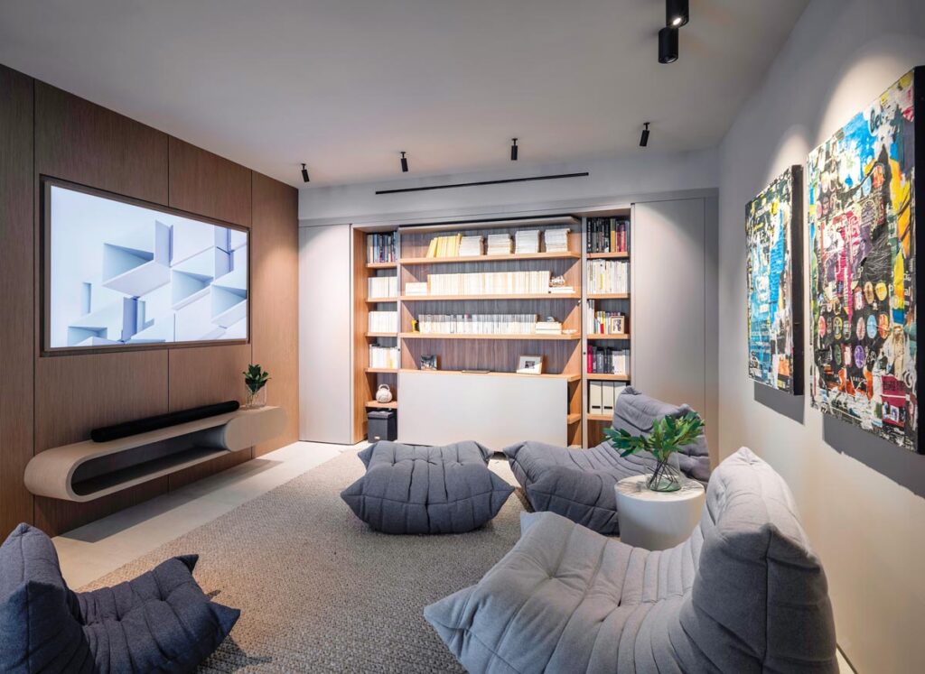 “The homeowners wanted a polyvalent space that could serve as a TV room, a den, an office, and a guest bedroom all at once,” says architect Mauricio Salazar. Sliding doors separate this room from the living area, and the back wall bookshelves pivot to reveal a Murphy bed. 