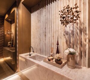 The powder room features a custom pink onyx vanity crafted from 56 individually cut pieces of stone. Illuminated from within, the translucent onyx transforms the piece into a sculptural focal point. A Missoni wallcovering complements the elegant aesthetic.