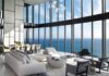 Modernist Grandeur in a Sunny Isles Beach Penthouse To balance the immense volume of the 20,000-square-foot residence’s main salon, designer Michael Wolk paired tailored Minotti seating with Maxalto chairs and a sculptural black Luminaire bench. The homeowners’ personal cocktail table anchors the central grouping, while in the background, a massive 12-person dining table from David Sutherland commands the room beneath a striking Smartline chandelier.