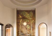 Inside a Central Florida Retreat Inspired by the Everglades The grand living room is anchored with Studio Piet Boon’s Derk sofas and carved marble coffee tables by Francesco Balzano. A custom mural by En-Viu pays homage to the Central Florida alligators and plant life surrounding the residence.