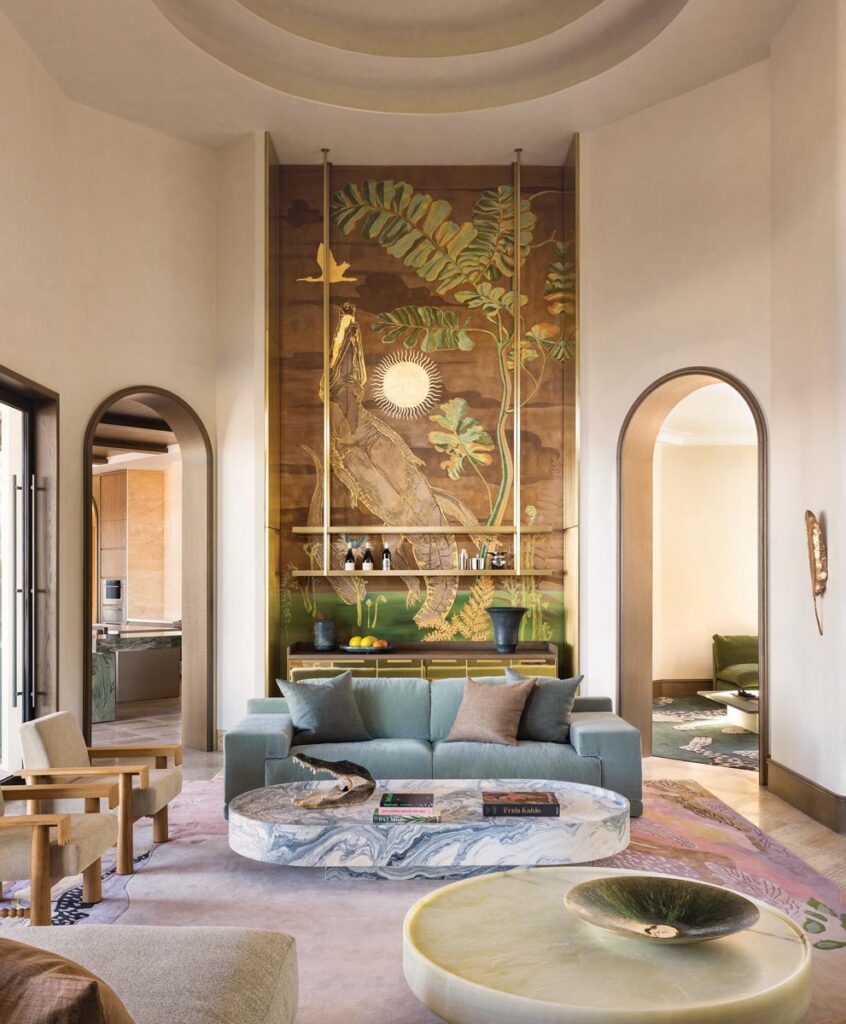 The grand living room is anchored with Studio Piet Boon’s Derk sofas and carved marble coffee tables by Francesco Balzano. A custom mural by En-Viu pays homage to the Central Florida alligators and plant life surrounding the residence.