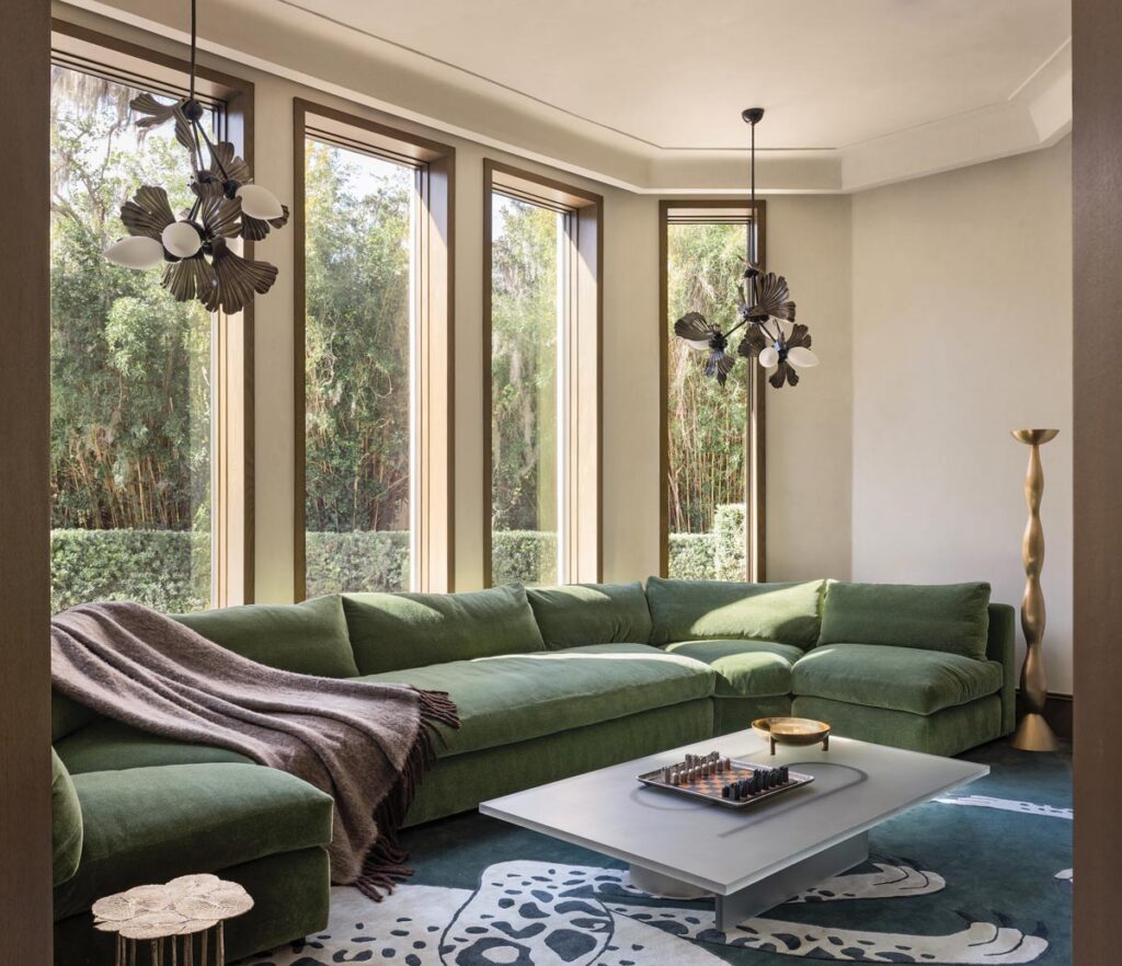 The green Montauk Sofa sectional in the media room was custom fabricated to fit the space. Rosie Li Ginkgo pendants hang like jewelry pieces above a resin coffee table by Francesco Balzano.