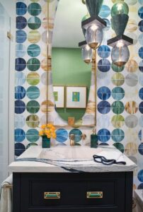 A wall of colorful mosaics from Artistic Tile makes the powder room a true jewel box of a space