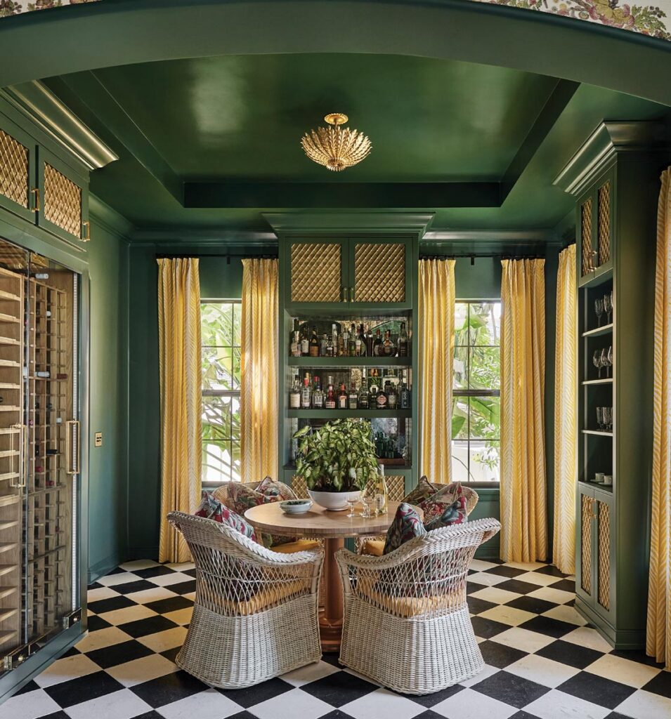Anchored by a custom table from Boyd & Allister, a wine room cloaked in rich green high-gloss paint and classic black-and-white checkered stone floors is immediately welcoming.