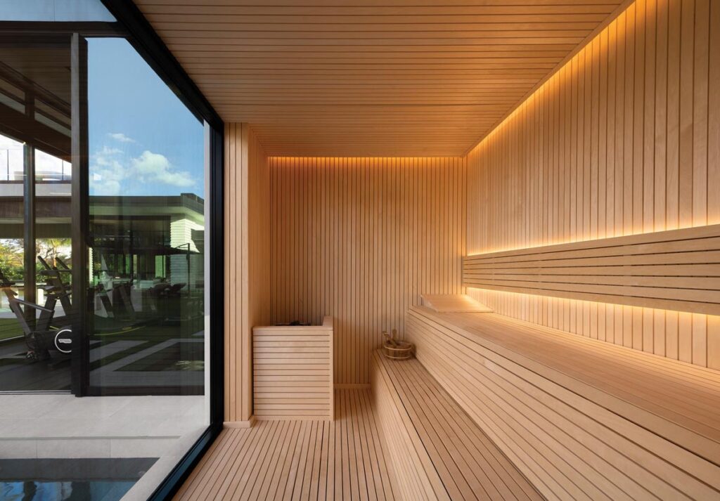 Encased in rich cedar, the custom sauna serves as an intimate thermal retreat within the home’s expansive wellness wing