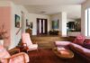 Retro Soul Abounds in Gainesville Home The split-level layout of the home’s living room was celebrated rather than minimized. The design team approached the space like a “conversation pit,” arranging low, sculptural furniture that encourages gathering while allowing the architecture to remain the focal point. The original dimensional wall becomes a backdrop rather than simply an accent.