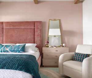 “We chose a slightly deeper teal for the fabrics of the primary bedroom and paired them with a serene blush pink headboard,” says Gaddis. “Natural wood tones ground the room and keep the layered color palette feeling warm, relaxed, and inviting.”